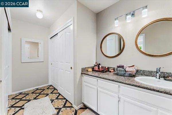 a bathroom with a granite countertop double vanity sink and a mirror