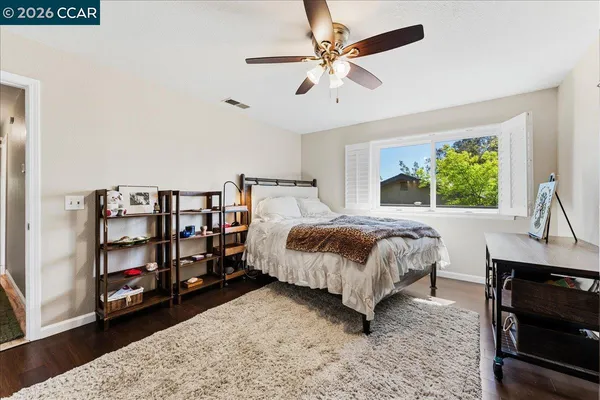 a bedroom with a bed a book shelf and a window