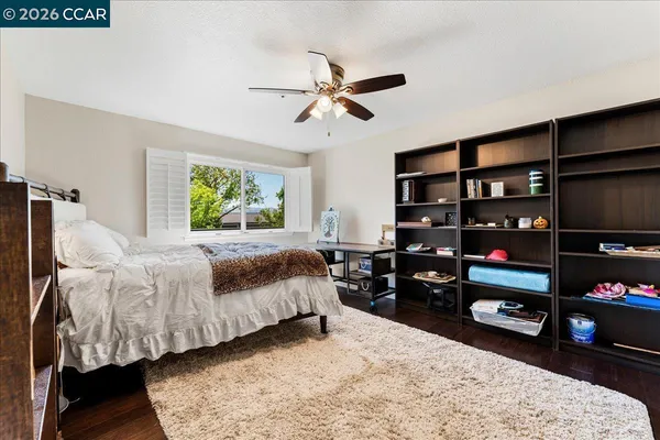 a bedroom with a bed a dresser and a window