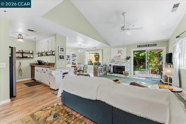 a living room with stainless steel appliances kitchen island furniture and a fireplace