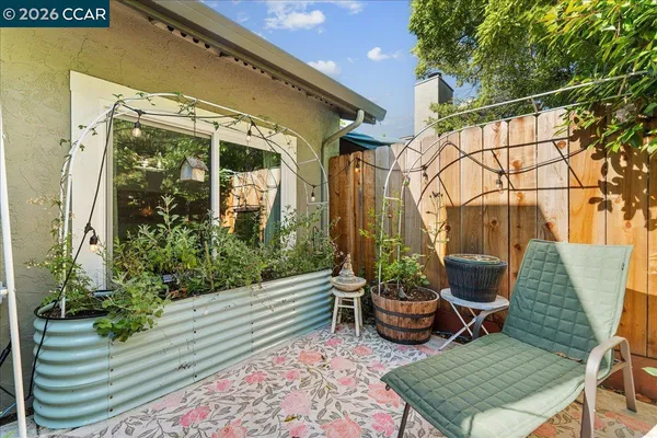 a view of a chair and table in backyard of the house