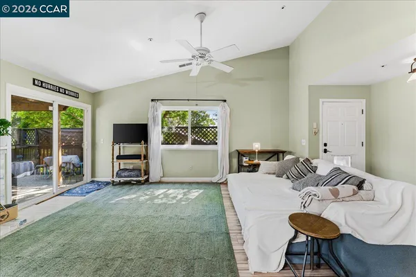 a living room with furniture a flat screen tv and a large window