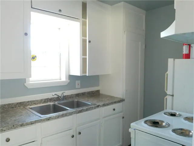 a kitchen with a sink stove and refrigerator