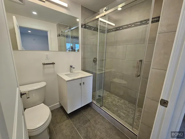 a bathroom with a shower a toilet and a sink