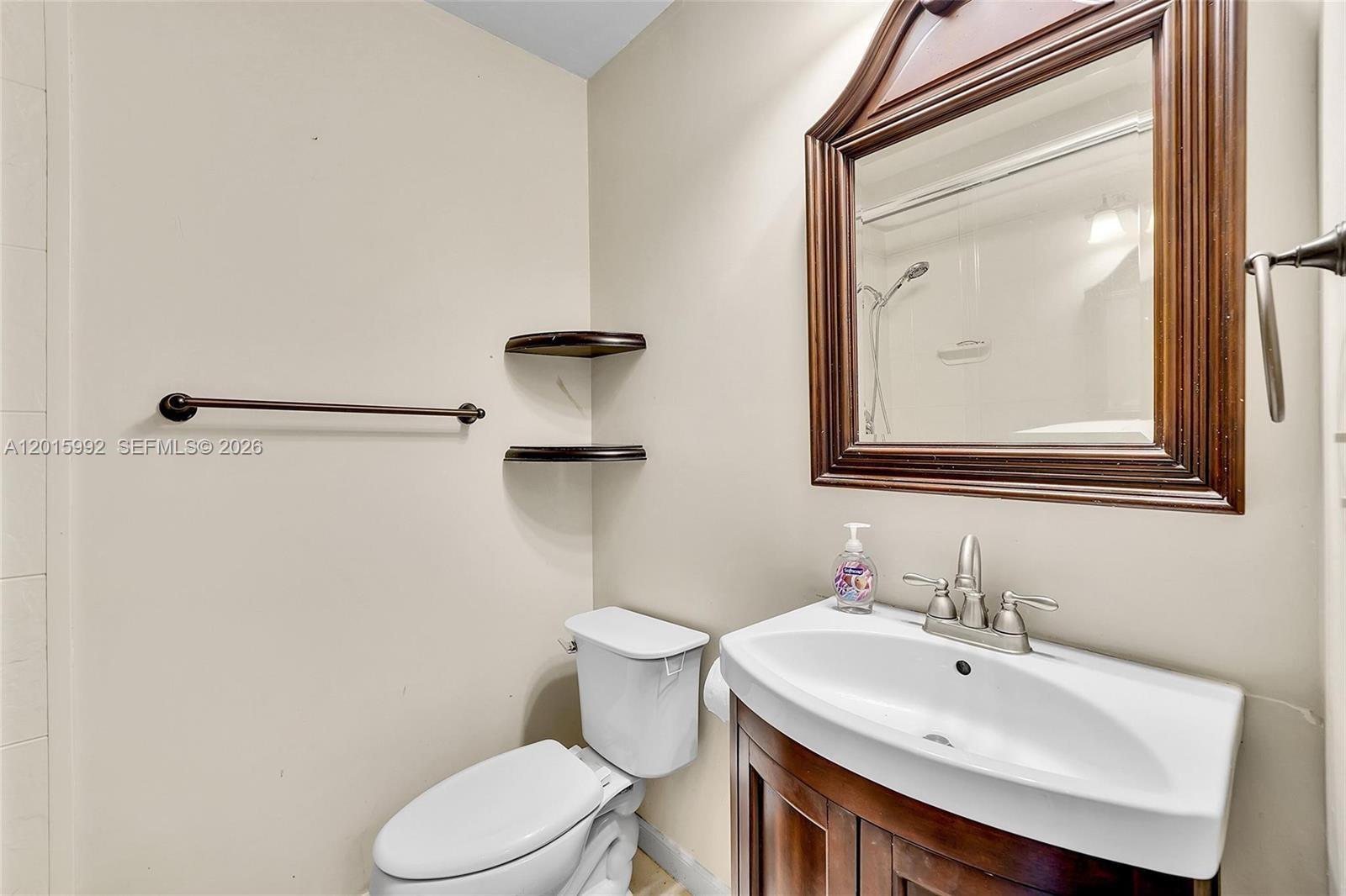 3300 Atlanta Street, Unit 15F Hollywood, FL 33021 - Photo 19 of 30 a bathroom with a toilet sink and mirror