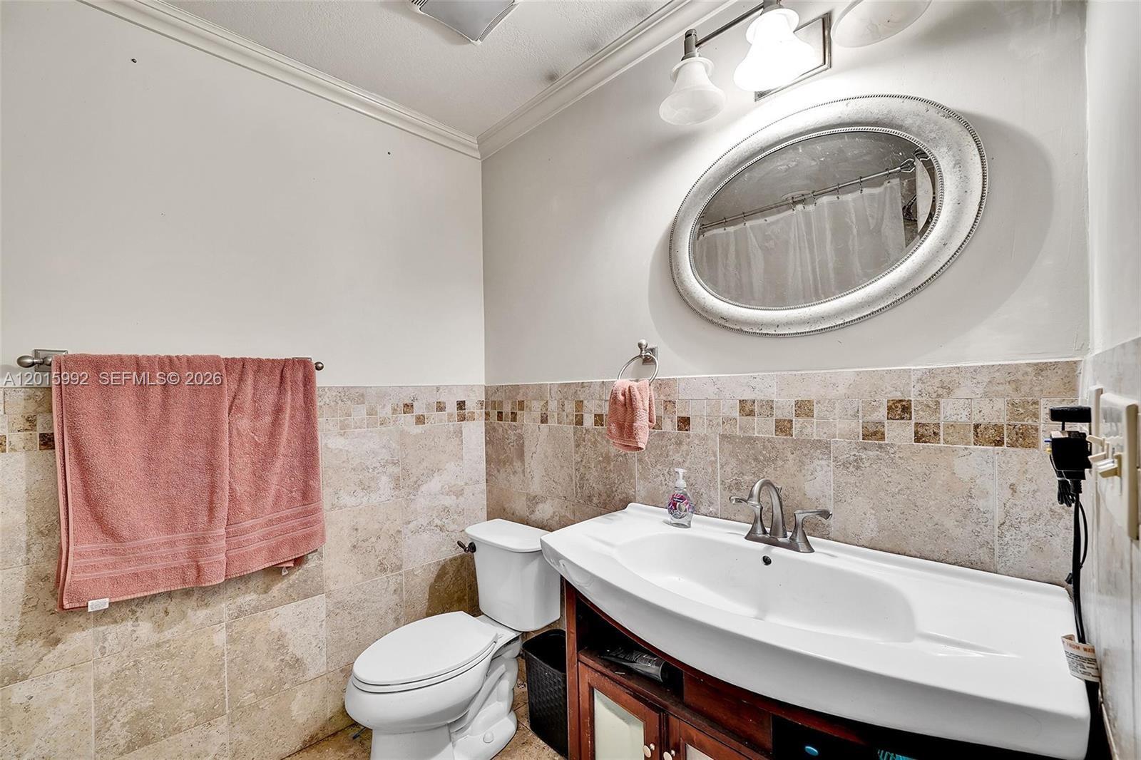 3300 Atlanta Street, Unit 15F Hollywood, FL 33021 - Photo 7 of 30 a bathroom with a sink a toilet and a mirror