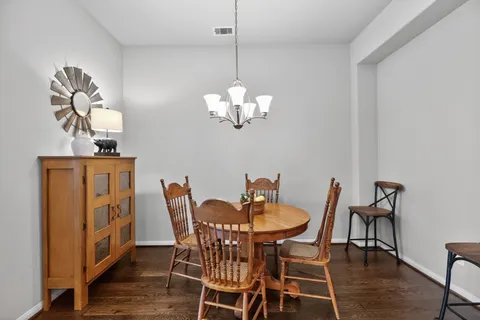 a dining room with furniture wooden floor a rug and a chandelier