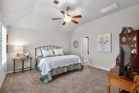 a bedroom with a bed and a flat tv screen on the dresser
