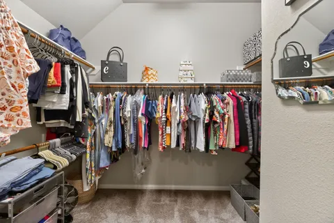 a view of walk in closet with clothes