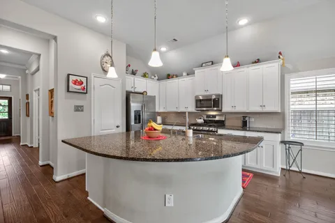 an open kitchen with wooden floor and window