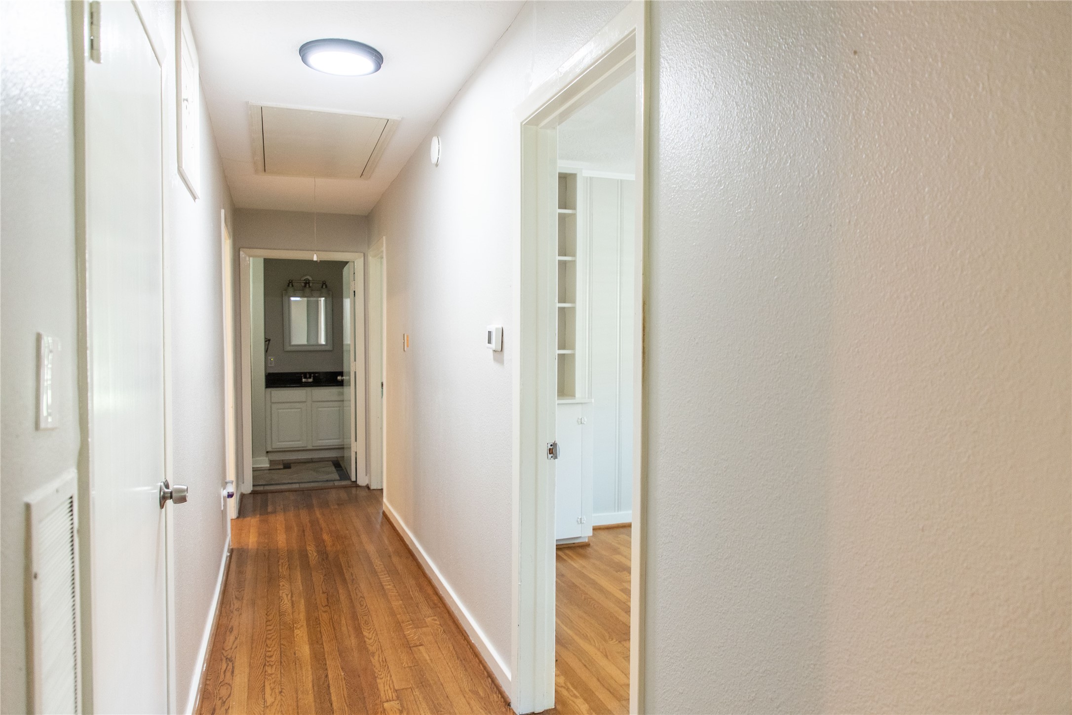 3314 Rochdale Street Houston, TX 77025 - Photo 25 of 29 a view of a hallway with wooden floor and a bathroom