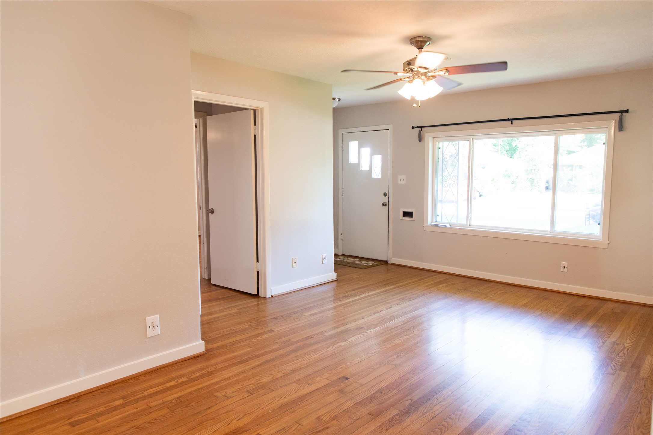 3314 Rochdale Street Houston, TX 77025 - Photo 4 of 29 a view of an empty room with wooden floor and a window