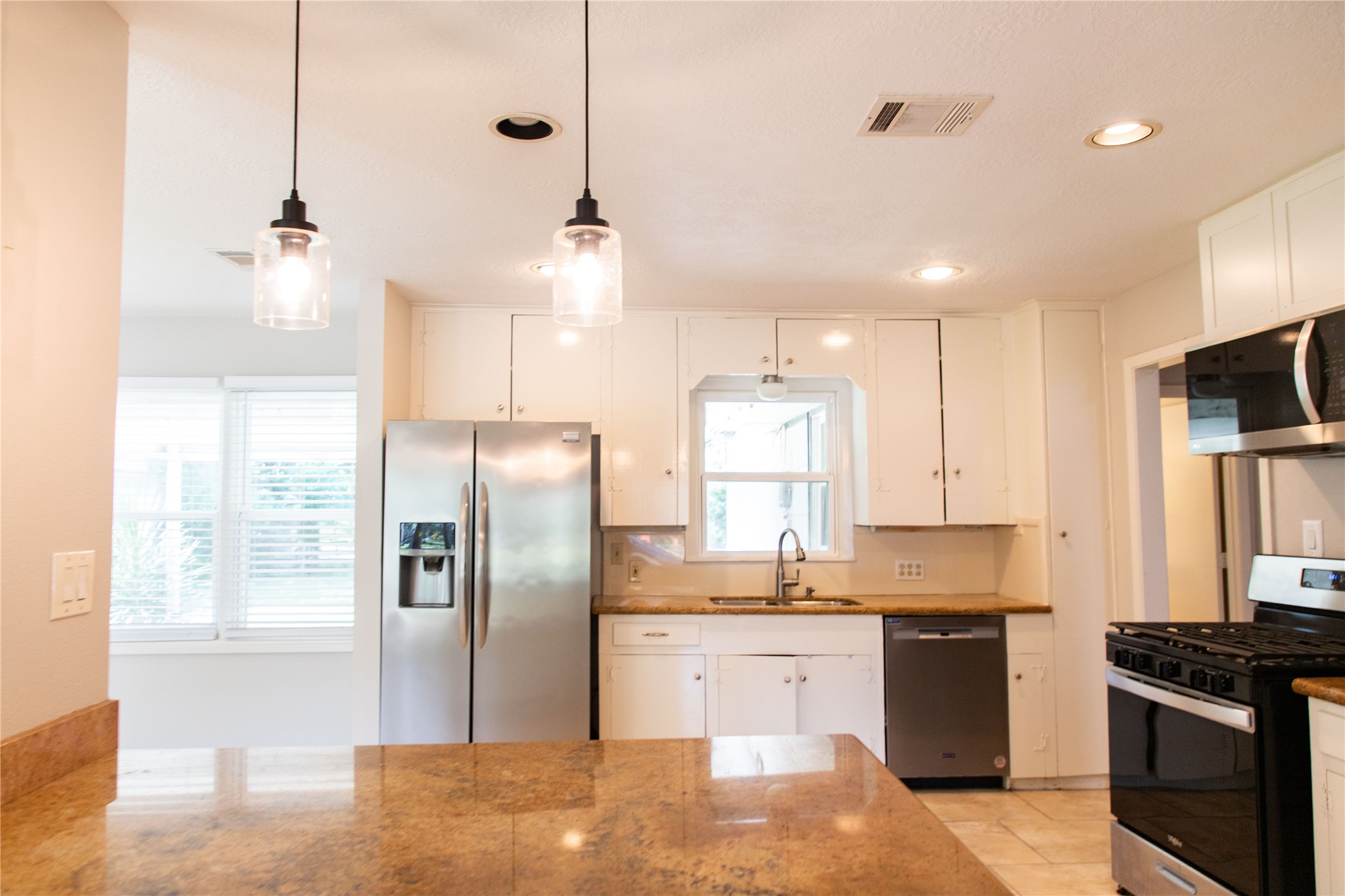 3314 Rochdale Street Houston, TX 77025 - Photo 5 of 29 a kitchen with stainless steel appliances granite countertop a refrigerator a sink a stove and white cabinets