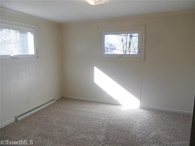 6804 Ivy Lane Oak Ridge, NC 27310 - Photo 12 of 16 2nd Bedroom. The 2 nd bedroom has brand new carpet, as well, and neutral paint.