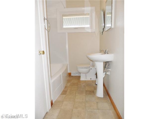 6804 Ivy Lane Oak Ridge, NC 27310 - Photo 13 of 16 Bath. The Bathroom features a pedestal sink, neutral flooring and a brand new tub surround!