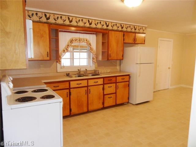 6804 Ivy Lane Oak Ridge, NC 27310 - Photo 9 of 16 Kitchen. The oversized kitchen features wood cabinetry, neutral flooring and paint. The built in microwave, free standing range/oven, refrigerator are all included in the list price!
