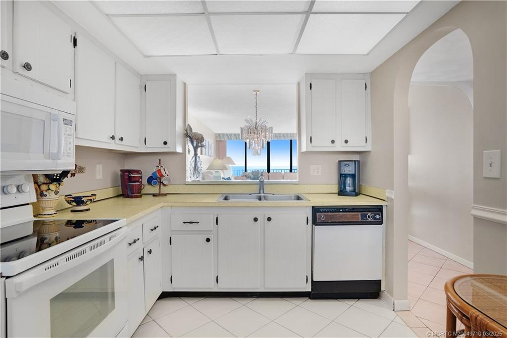 3200 North Hwy A1A, Unit 805 Fort Pierce, FL 34949 - Photo 11 of 43 a kitchen with cabinets appliances a sink and a counter space