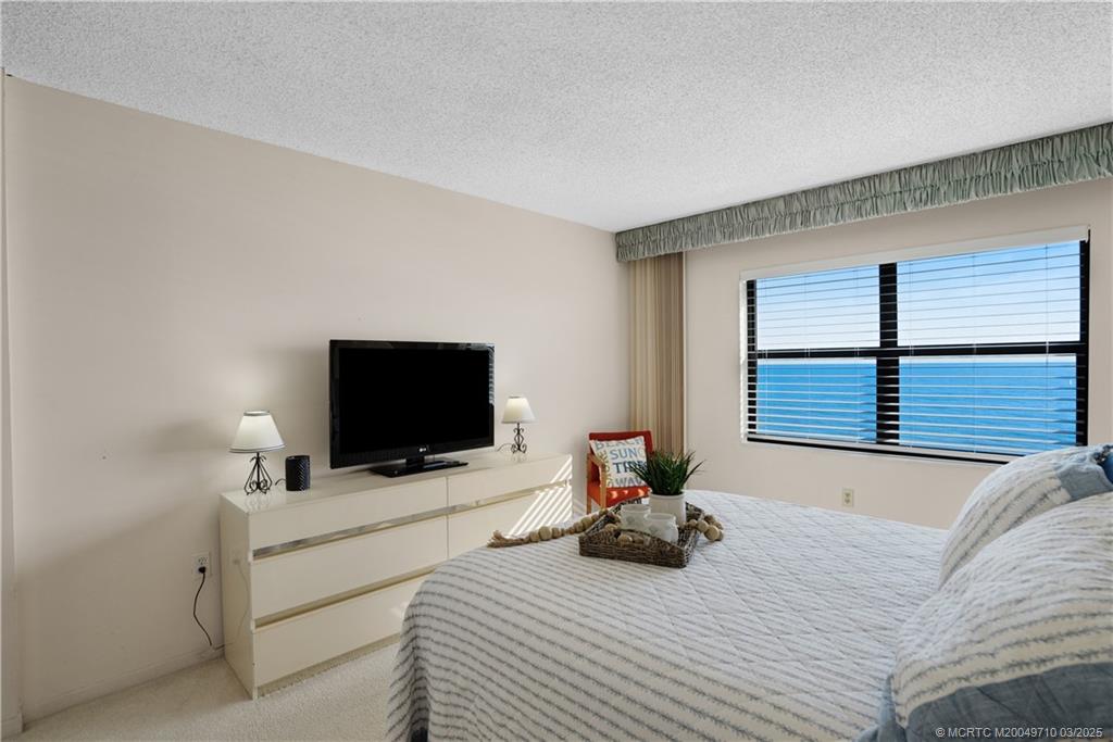 3200 North Hwy A1A, Unit 805 Fort Pierce, FL 34949 - Photo 23 of 43 a bedroom with a bed and flat screen tv