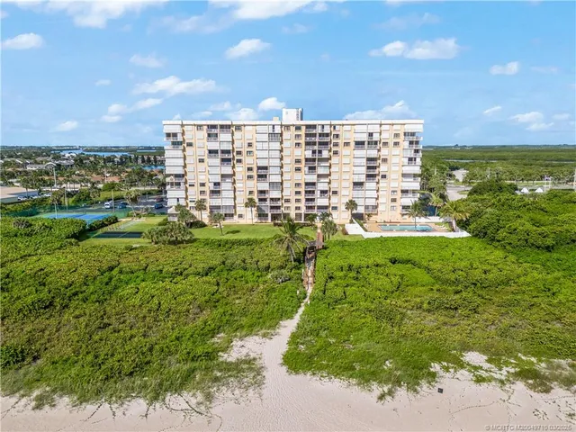 a view of a backyard with swimming pool and sitting area