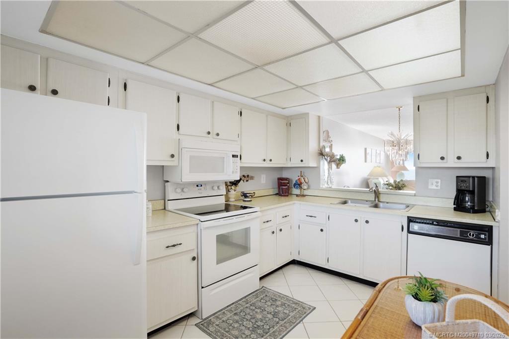 3200 North Hwy A1A, Unit 805 Fort Pierce, FL 34949 - Photo 10 of 43 a kitchen with cabinets appliances a sink and a counter space