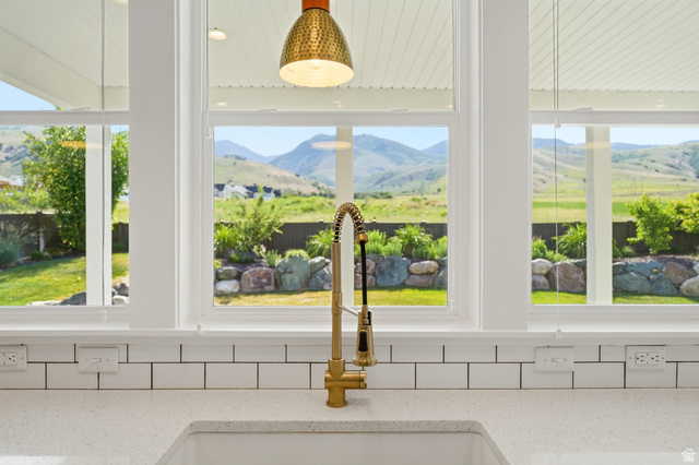 338 Windy Rdg Drive Smithfield, UT 84335 - Photo 15 of 63 Kitchen sink area featuring a gold-tone faucet, white subway tile backsplash, and light-toned countertop