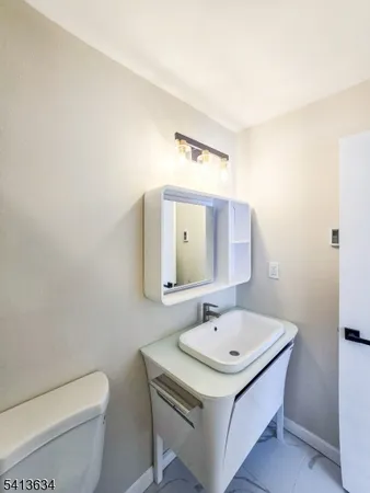 a bathroom with a sink a toilet and mirror