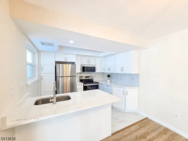 a kitchen with stainless steel appliances a sink and a refrigerator