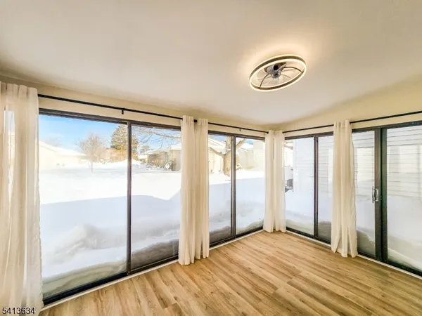 a view of a room with wooden floor and windows
