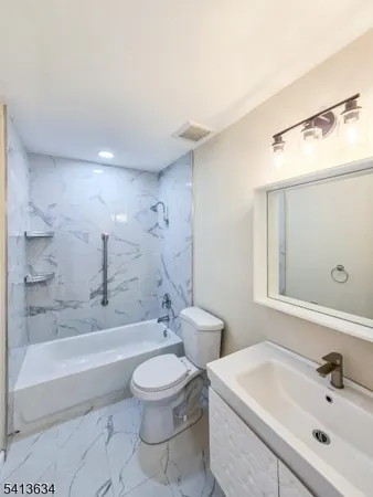 a bathroom with a toilet a sink and bathtub