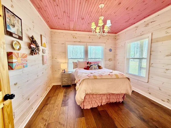 a bed sitting in a bedroom next to a window