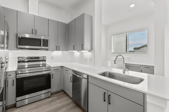 a kitchen with appliances a sink and cabinets