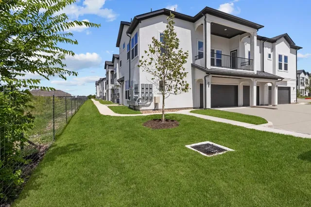 a view of a big house with a big yard and palm trees