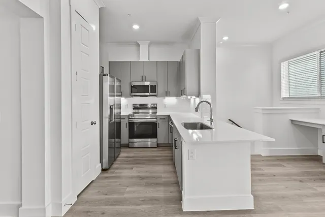 a kitchen with kitchen island a sink stove and refrigerator