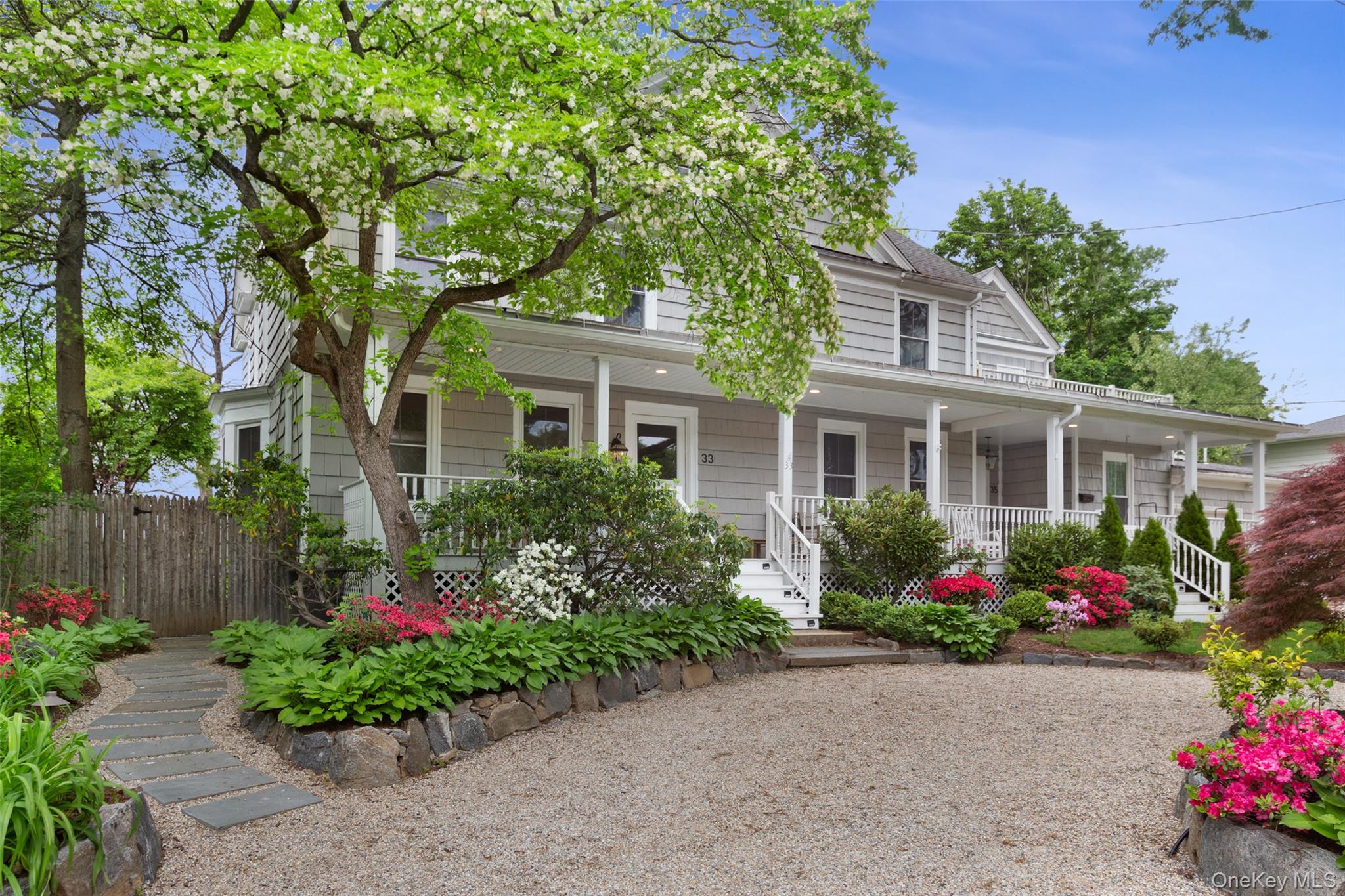a front view of a house with a yard and a garden