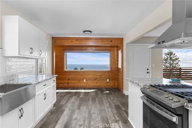 a kitchen with granite countertop a stove and a sink