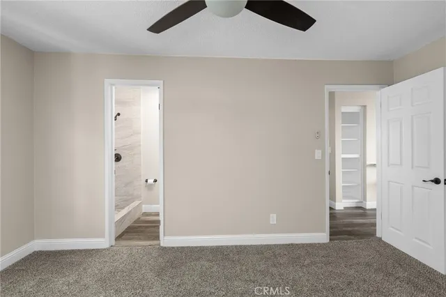 an empty room with closet and windows