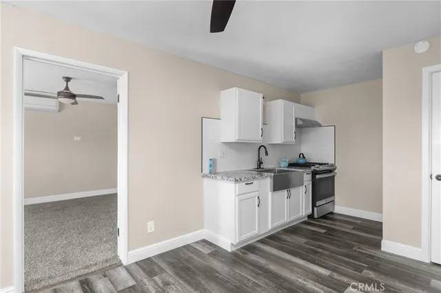 a kitchen with stainless steel appliances a stove a sink and white cabinets