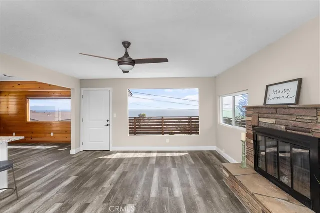 a view of a room with a flat screen tv ceiling fan and window