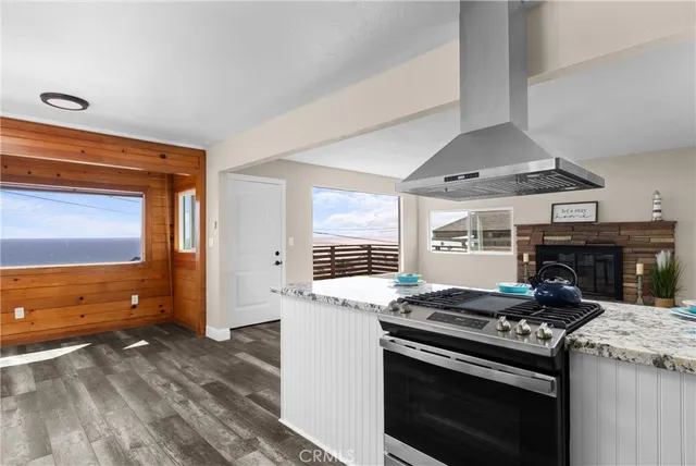 a kitchen with a stove and a wooden floor