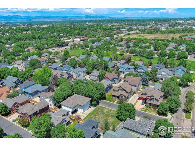 an aerial view of residential houses with outdoor space and trees
