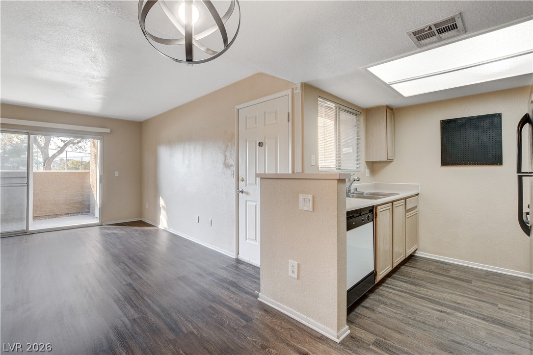 8070 West Russell Road, Unit 1064 Las Vegas, NV 89113 - Photo 11 of 35 Kitchen with light countertops, dark wood-style flooring, a textured ceiling, dishwasher, and light wood finish cabinets