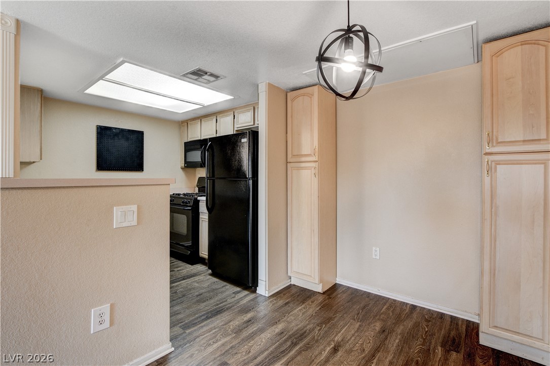 8070 West Russell Road, Unit 1064 Las Vegas, NV 89113 - Photo 12 of 35 Kitchen featuring light wood finish cabinets, black appliances, decorative light fixtures, and dark wood-style flooring
