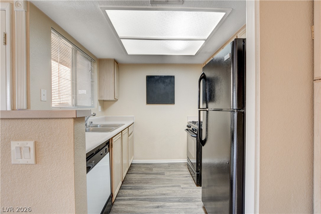 8070 West Russell Road, Unit 1064 Las Vegas, NV 89113 - Photo 13 of 35 Kitchen featuring black appliances, light countertops, light wood-style floors, and light wood finish cabinets
