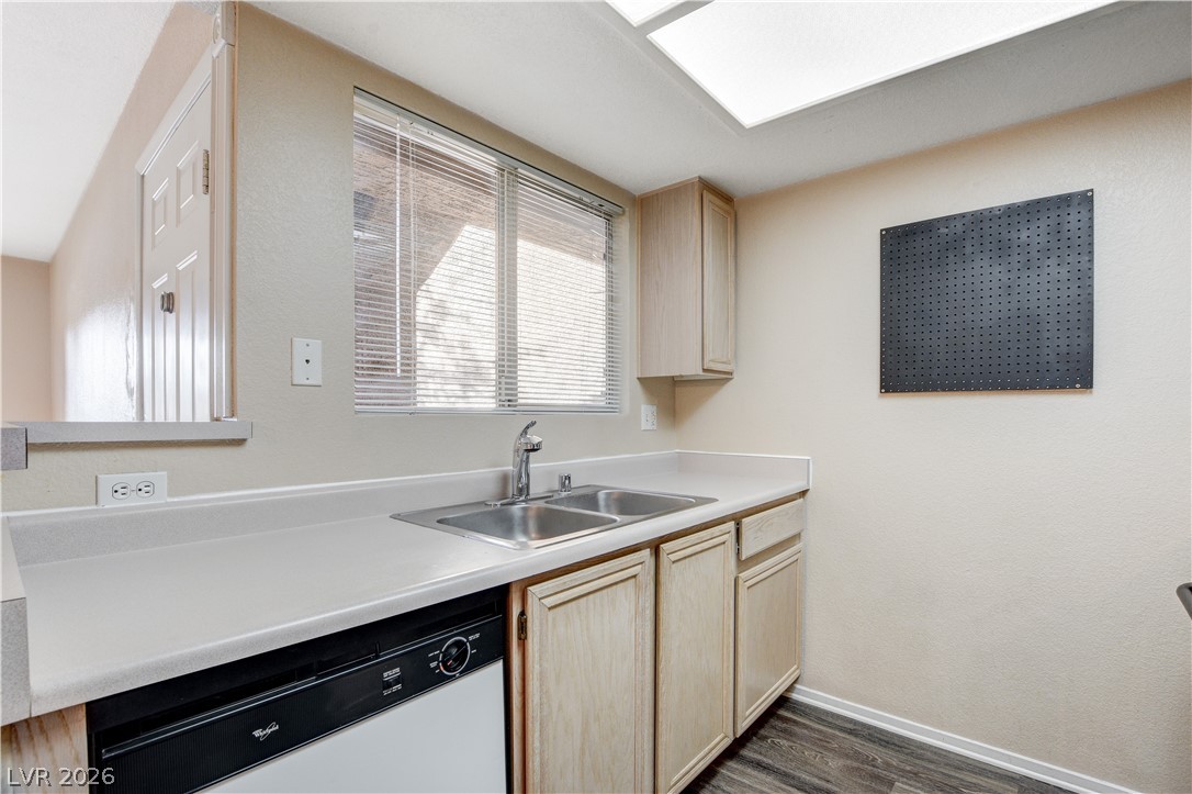 8070 West Russell Road, Unit 1064 Las Vegas, NV 89113 - Photo 14 of 35 Kitchen with light wood finish cabinetry, light countertops, white dishwasher, dark wood-type flooring, and a textured wall