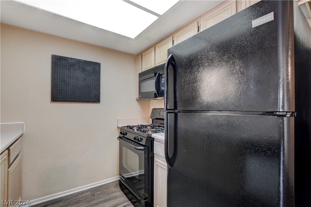 8070 West Russell Road, Unit 1064 Las Vegas, NV 89113 - Photo 15 of 35 Kitchen with black appliances, dark wood-style flooring, light countertops, and light wood finish cabinetry