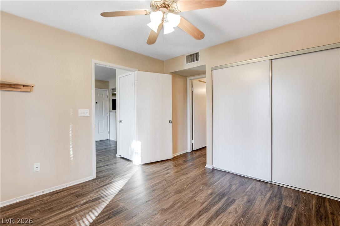8070 West Russell Road, Unit 1064 Las Vegas, NV 89113 - Photo 18 of 35 Unfurnished bedroom with dark wood-style flooring, ceiling fan, and a closet