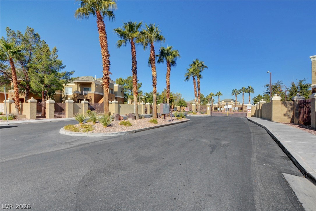 8070 West Russell Road, Unit 1064 Las Vegas, NV 89113 - Photo 34 of 35 View of asphalt street featuring sidewalks, curbs, a gate, a residential view, and a gated entry