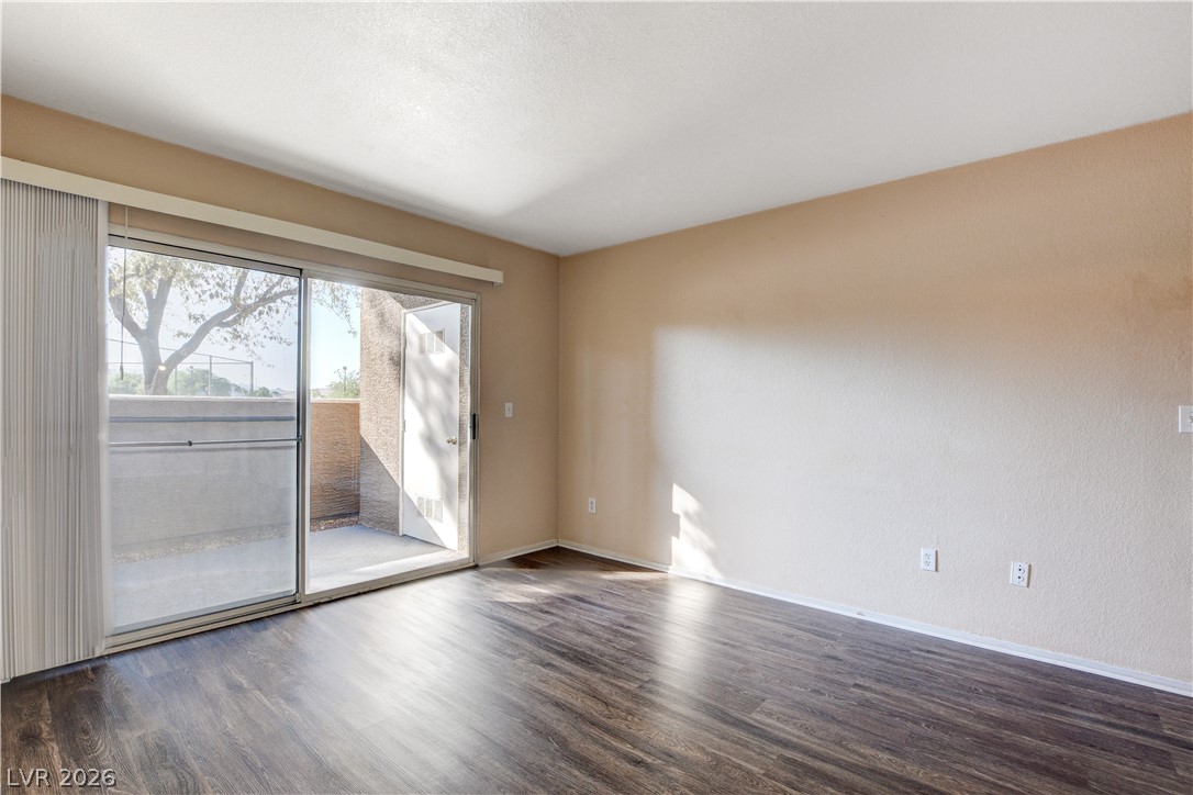 8070 West Russell Road, Unit 1064 Las Vegas, NV 89113 - Photo 6 of 35 Empty room with dark wood-type flooring and baseboards