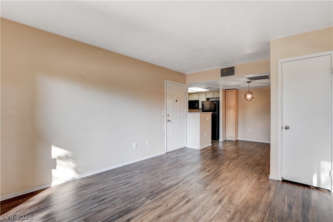 8070 West Russell Road, Unit 1064 Las Vegas, NV 89113 - Photo 7 of 35 Unfurnished living room with dark wood-style flooring and baseboards