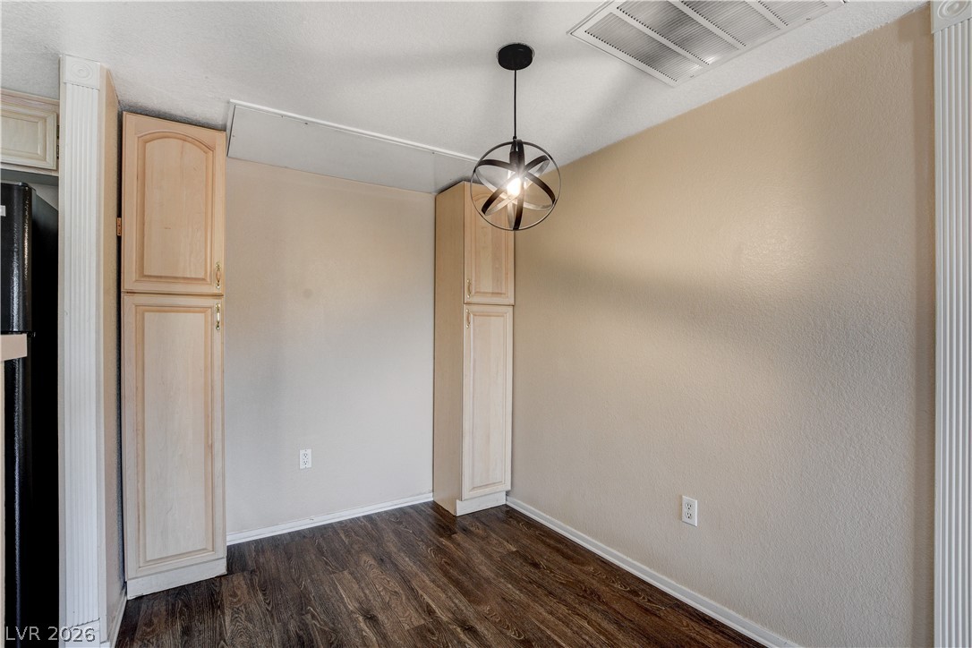8070 West Russell Road, Unit 1064 Las Vegas, NV 89113 - Photo 9 of 35 Unfurnished dining area with baseboards and dark wood-style floors